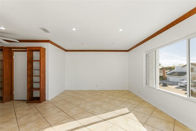 tiled empty room featuring ceiling fan and crown molding