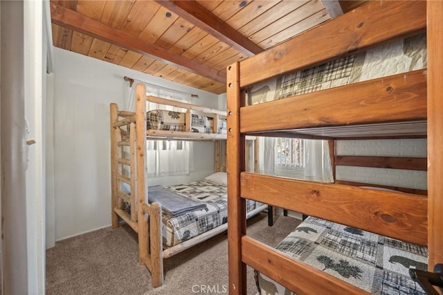 carpeted bedroom featuring beam ceiling and wooden ceiling