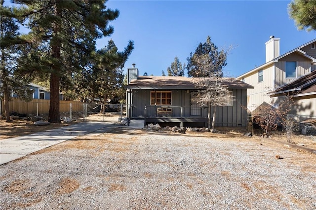 view of front of house with a porch, fence, and driveway