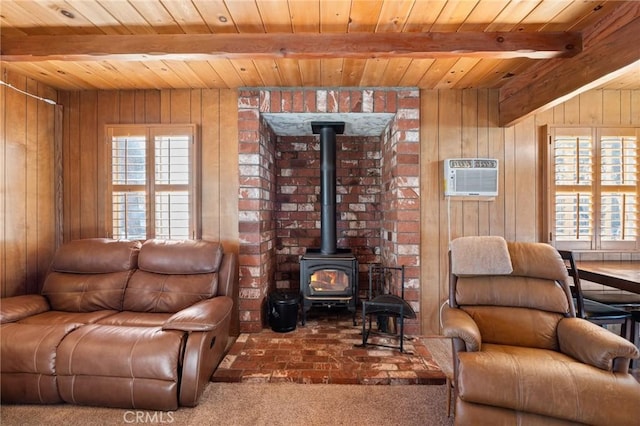 living area with beam ceiling, a healthy amount of sunlight, and a wood stove