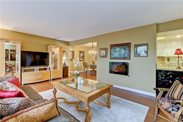 living room featuring an inviting chandelier and light hardwood / wood-style floors