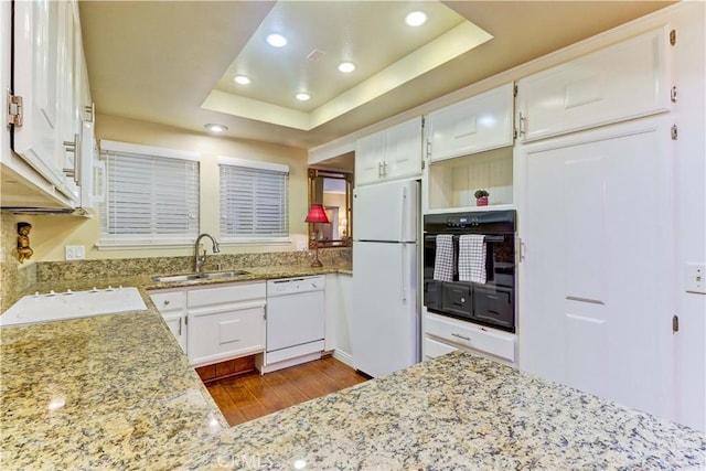 kitchen featuring white cabinetry, sink, a raised ceiling, and white appliances