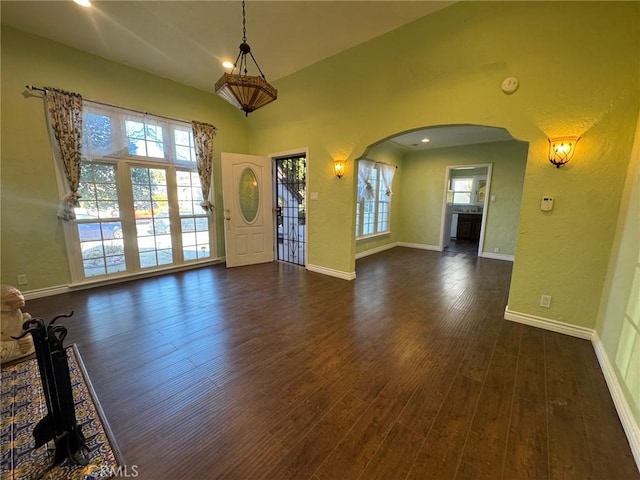 interior space featuring vaulted ceiling, dark wood-type flooring, and a wealth of natural light