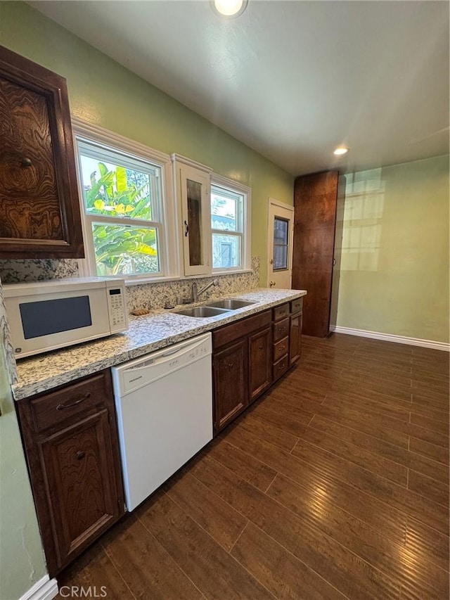 kitchen featuring dark hardwood / wood-style floors, sink, white appliances, and dark brown cabinetry