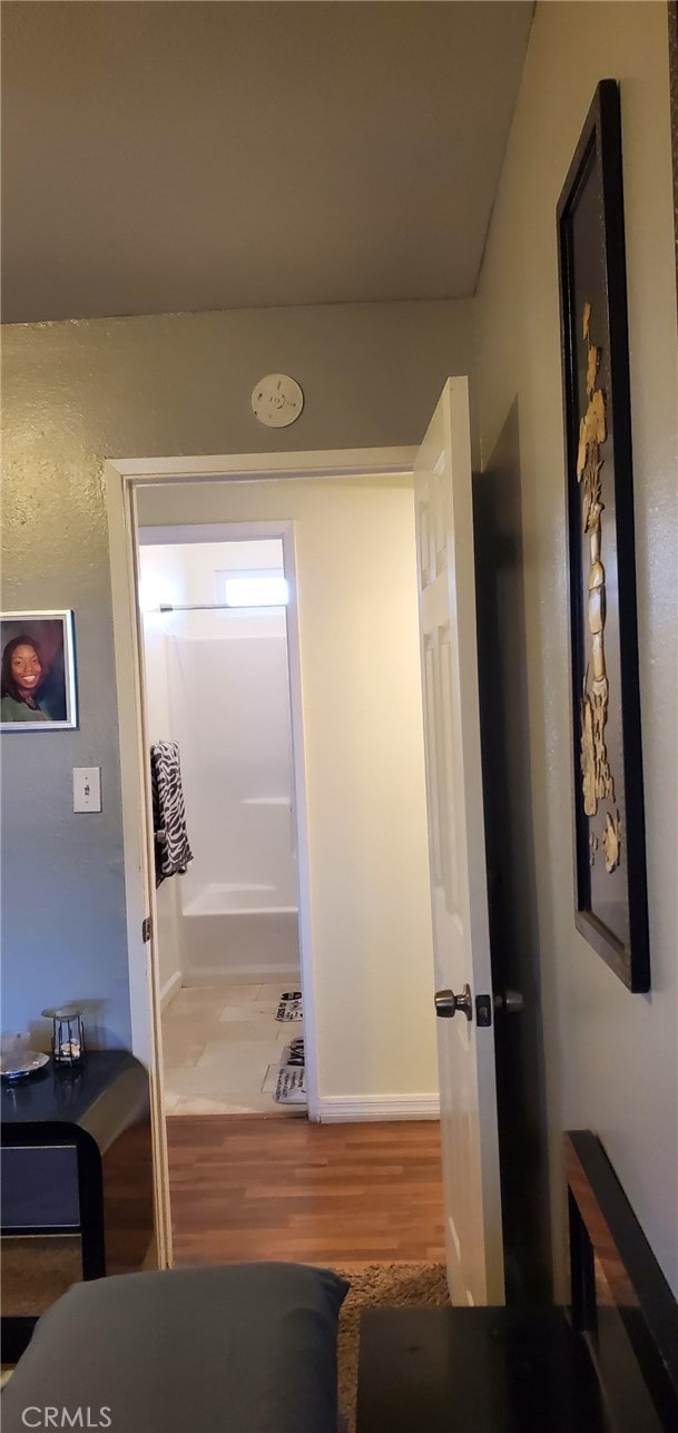 corridor with hardwood / wood-style flooring