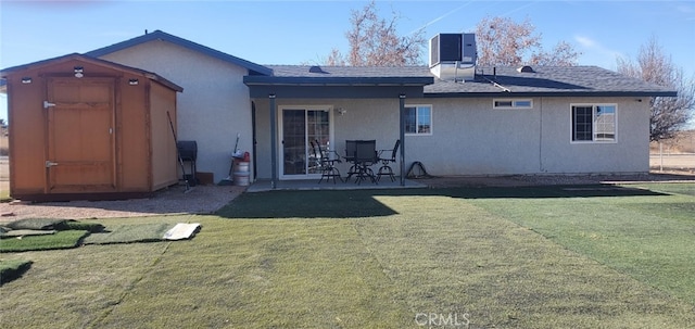 back of house with a storage shed, central air condition unit, and a yard