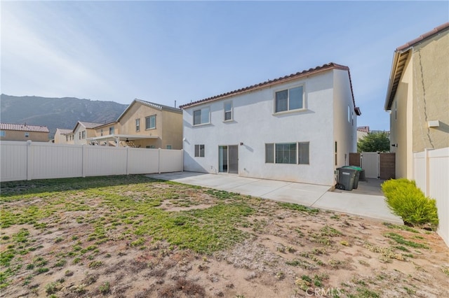 rear view of house featuring a patio area and a mountain view