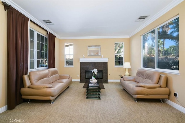 carpeted living room with plenty of natural light, ornamental molding, and a fireplace