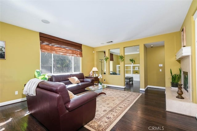 living room featuring dark hardwood / wood-style floors and a premium fireplace