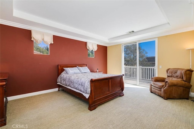 bedroom with access to outside, a tray ceiling, and carpet flooring