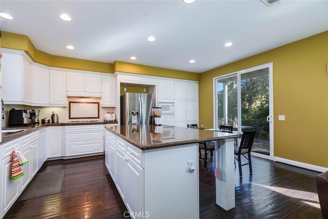 kitchen with white cabinetry, stainless steel fridge, and a center island