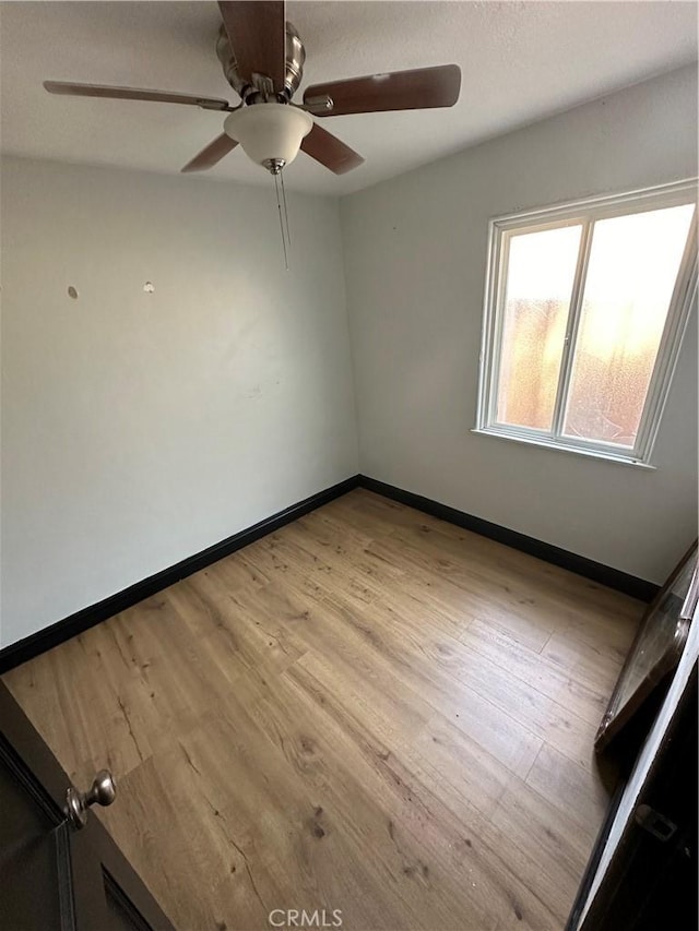 unfurnished room featuring light wood-type flooring and ceiling fan