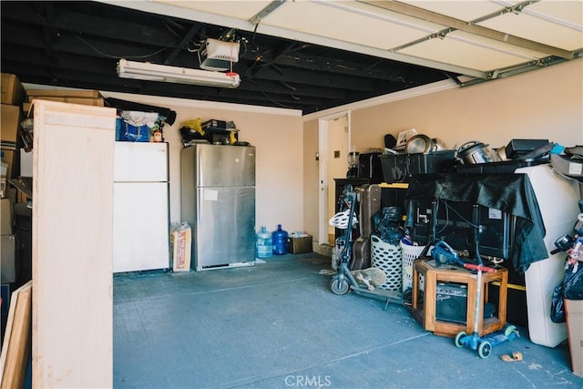 garage featuring a garage door opener, stainless steel refrigerator, and white refrigerator