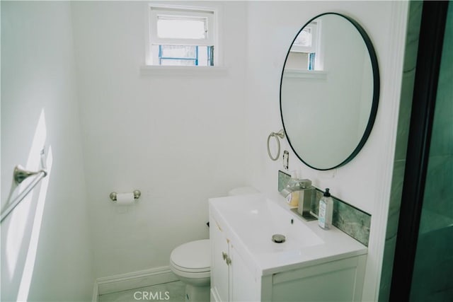 bathroom with toilet, vanity, and tile patterned floors