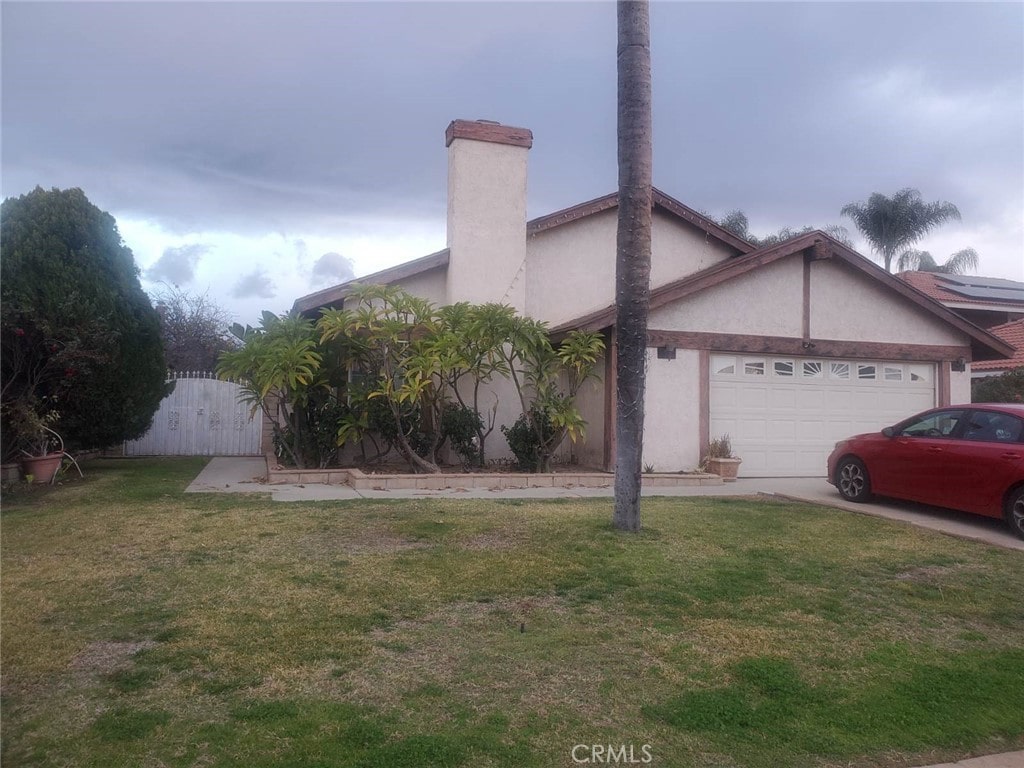 view of front of property with a garage and a front lawn