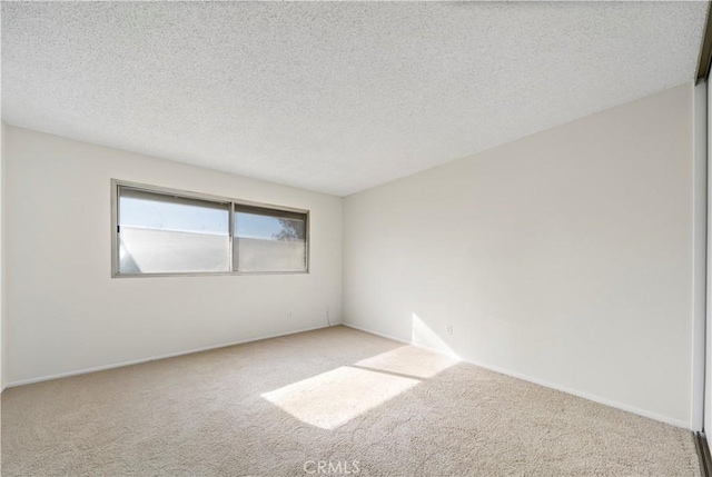 unfurnished room with light carpet and a textured ceiling