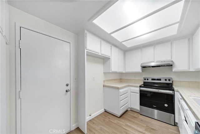 kitchen with tile countertops, white cabinets, stainless steel electric stove, and light hardwood / wood-style floors