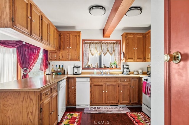 kitchen with kitchen peninsula, sink, white appliances, beamed ceiling, and dark hardwood / wood-style flooring