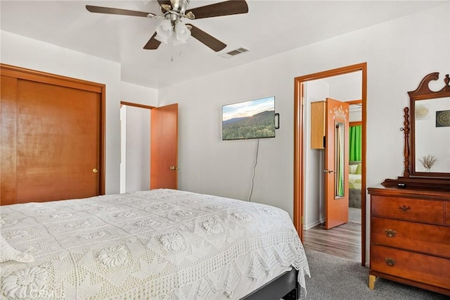 bedroom with ceiling fan, ensuite bathroom, a closet, and carpet floors