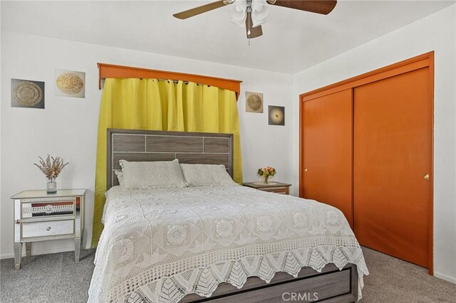 carpeted bedroom with ceiling fan and a closet