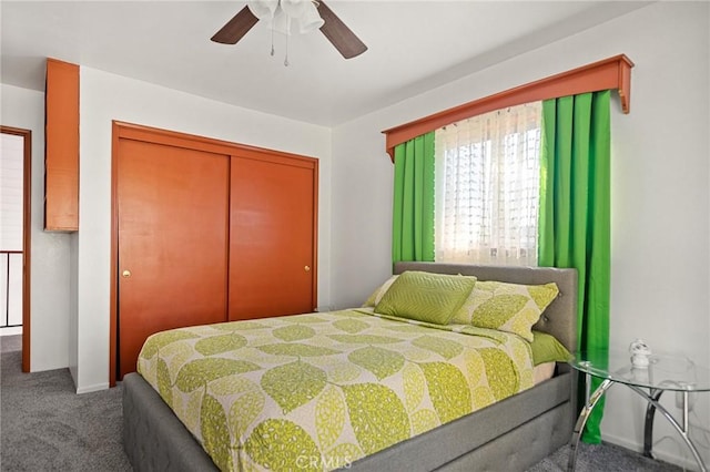 carpeted bedroom with ceiling fan and a closet