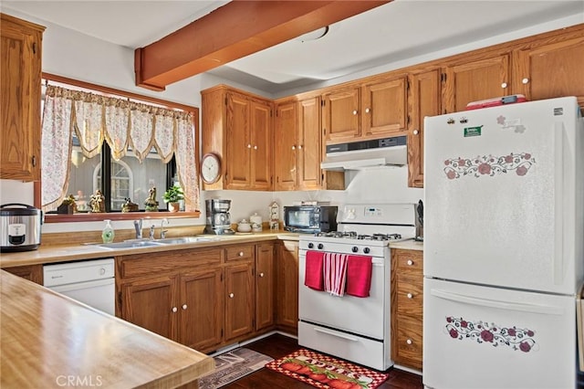 kitchen featuring sink, white appliances, and beamed ceiling