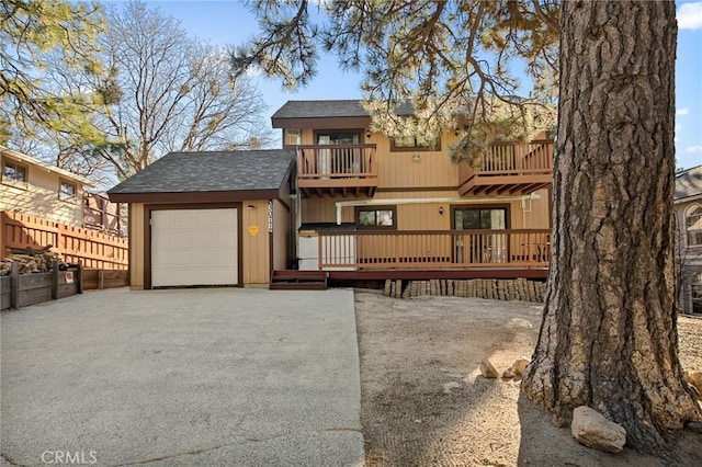 back of house with a balcony and a garage