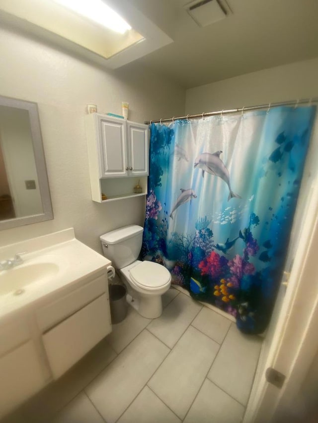 bathroom featuring tile patterned flooring, vanity, curtained shower, and toilet