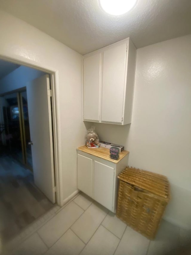 interior space with a textured ceiling and light tile patterned floors