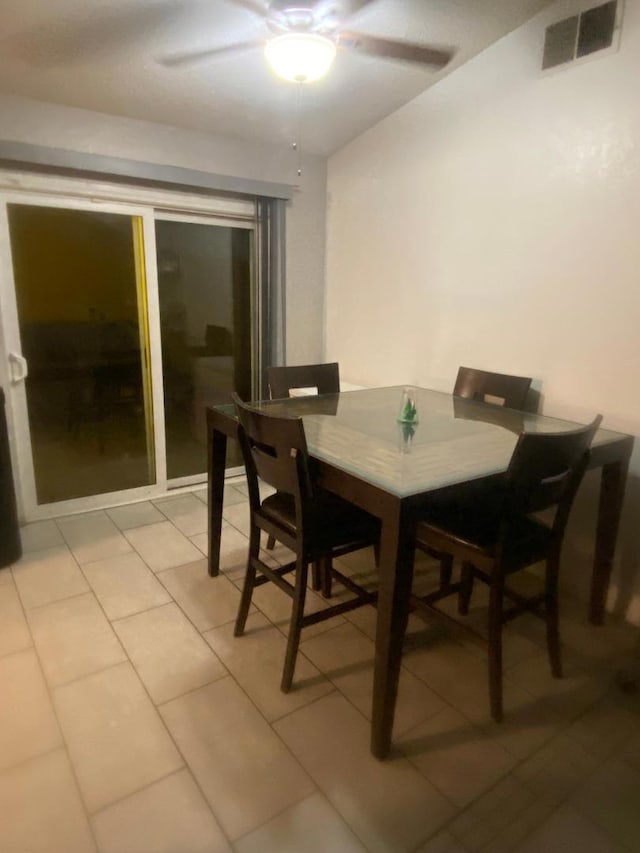 tiled dining space featuring ceiling fan