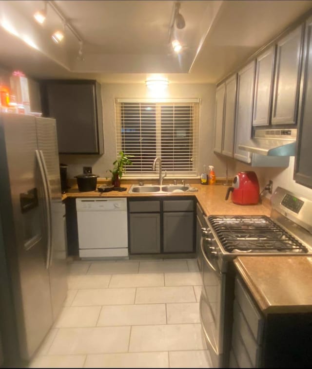 kitchen featuring gray cabinetry, extractor fan, sink, and appliances with stainless steel finishes