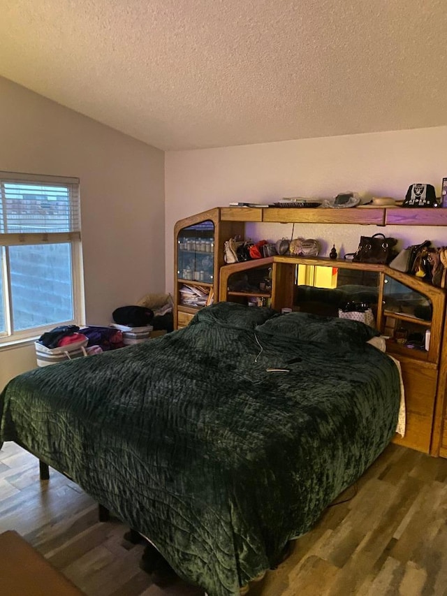 bedroom featuring hardwood / wood-style floors and a textured ceiling