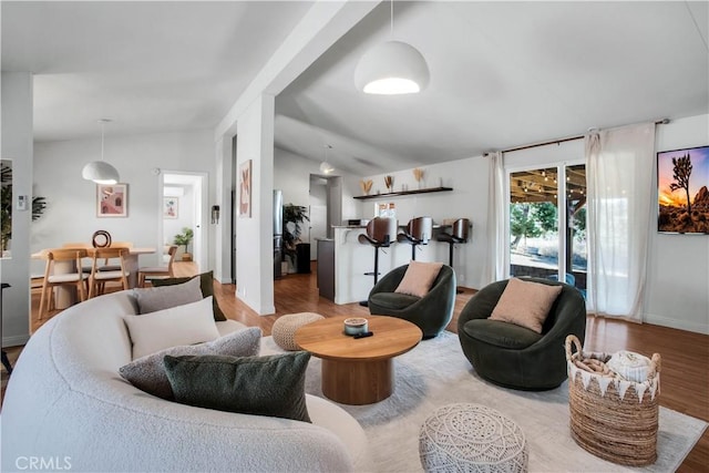 living room featuring lofted ceiling and light hardwood / wood-style floors