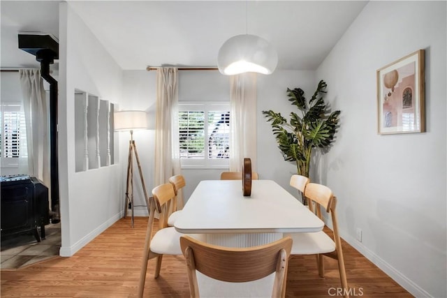 dining room featuring light wood-type flooring and a wood stove