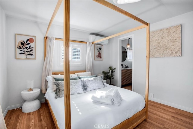 bedroom featuring a wall mounted AC and hardwood / wood-style floors