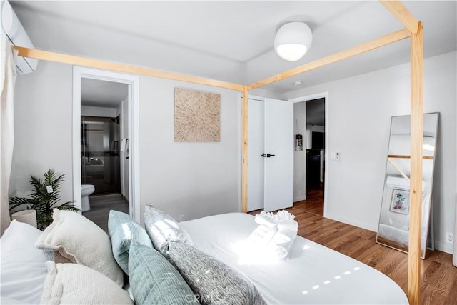 bedroom with ensuite bathroom and light wood-type flooring