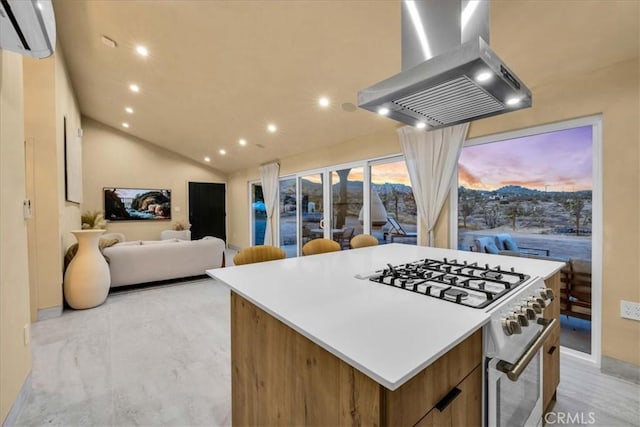 kitchen with lofted ceiling, a wall mounted air conditioner, high end range, a kitchen island, and island exhaust hood