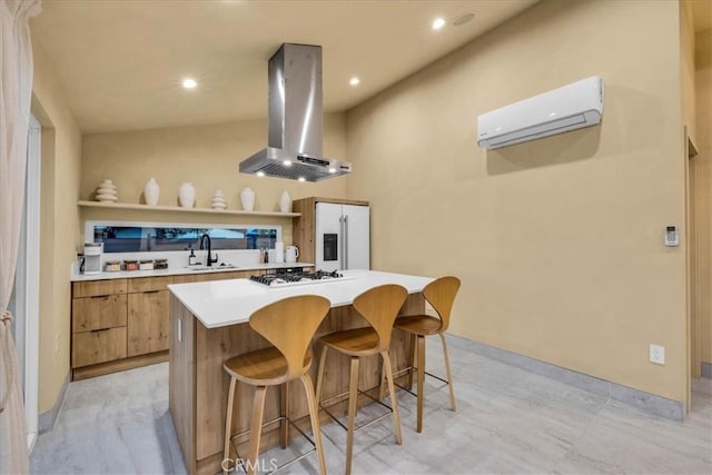 kitchen featuring a kitchen island, a wall mounted air conditioner, island range hood, sink, and a kitchen breakfast bar