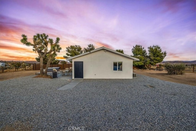 property exterior at dusk with a patio