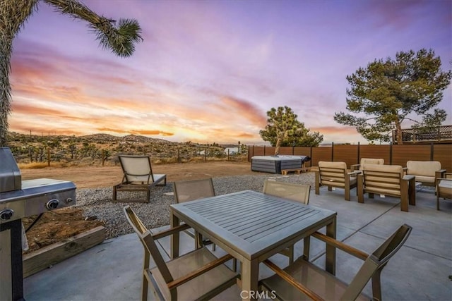 patio terrace at dusk featuring an outdoor hangout area and a hot tub