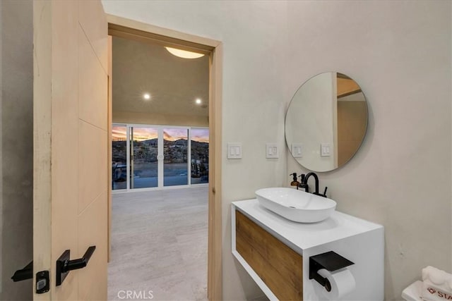 bathroom with a wall of windows, vanity, and toilet