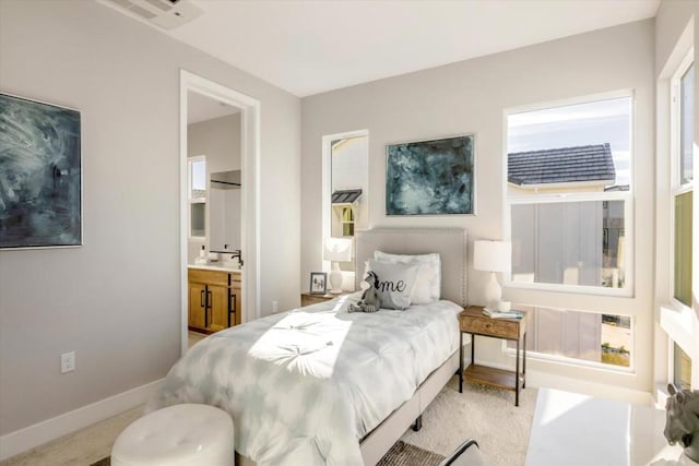 bedroom featuring light carpet and ensuite bath