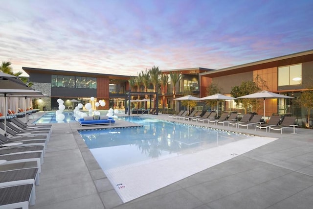 pool at dusk featuring a patio