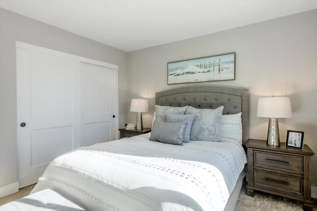 bedroom featuring light colored carpet and a closet