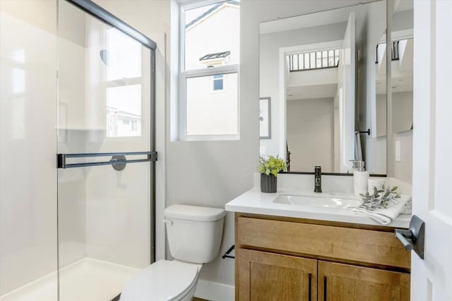 bathroom with vanity, a shower with shower door, and toilet