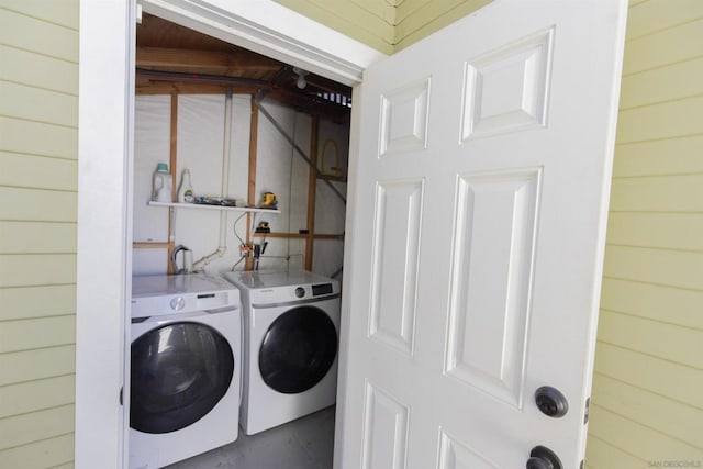 washroom with separate washer and dryer and wooden walls