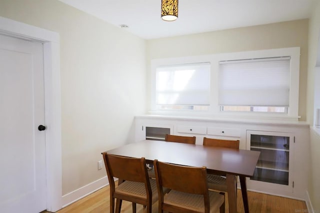 dining space with light hardwood / wood-style flooring and beverage cooler