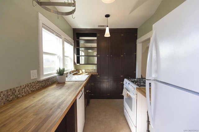 kitchen with white appliances, wooden counters, sink, decorative light fixtures, and dark brown cabinetry