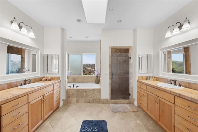 bathroom with vanity, a skylight, separate shower and tub, and tile patterned flooring