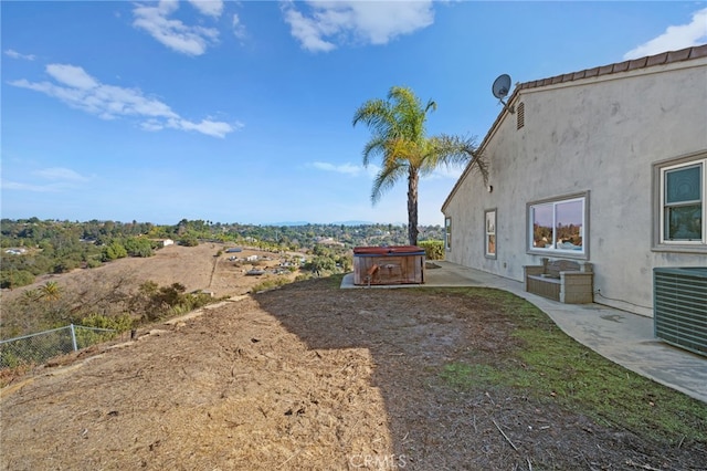 view of yard with central air condition unit, a patio area, and a hot tub